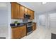 Modern kitchen with wood cabinets, stainless steel appliances, granite countertops and tiled floors at 410 Mockingbird Dr, Loganville, GA 30052