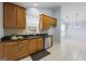 Kitchen with wooden cabinets, black granite countertops, stainless steel dishwasher, and tile flooring at 410 Mockingbird Dr, Loganville, GA 30052