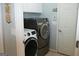 Well-lit laundry room features a modern washer and dryer set with cabinet storage and neutral paint at 410 Mockingbird Dr, Loganville, GA 30052