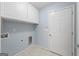 The laundry room features white cabinets, tile flooring and utility connections at 410 Mockingbird Dr, Loganville, GA 30052