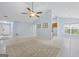 Open-concept living room with tile flooring, ceiling fan, and easy access to kitchen and front door at 410 Mockingbird Dr, Loganville, GA 30052