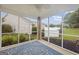 A screened porch with an outdoor fan and a blue rug, with an outside view of the fenced-in yard at 410 Mockingbird Dr, Loganville, GA 30052