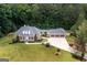 A spacious single-story home features a lush lawn, a three-car garage, mature trees, and a classic brick facade at 401 Robinson Rd, Peachtree City, GA 30269