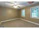 Finished basement with neutral walls, carpet, ceiling fan, and two windows at 401 Robinson Rd, Peachtree City, GA 30269
