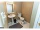 A charming powder room featuring a pedestal sink, toilet, and a neutral color palette at 401 Robinson Rd, Peachtree City, GA 30269