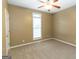 Neutral bedroom featuring tan walls, carpet, a ceiling fan, and natural light from a bright window at 401 Robinson Rd, Peachtree City, GA 30269