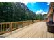 Wide wooden deck with a grill offers a perfect spot for entertaining with green tree views and outdoor relaxation at 401 Robinson Rd, Peachtree City, GA 30269