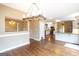 Open concept dining area leading to a modern kitchen, featuring hardwood floors and contemporary lighting at 401 Robinson Rd, Peachtree City, GA 30269