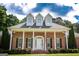 Lovely brick home with a dormered roof, a columned front porch, and mature landscaping at 401 Robinson Rd, Peachtree City, GA 30269