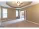 Spacious main bedroom with tray ceiling, carpet, and a view into the bathroom through double doors at 401 Robinson Rd, Peachtree City, GA 30269