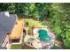Aerial view of a backyard pool with a large deck and mature trees at 401 Robinson Rd, Peachtree City, GA 30269
