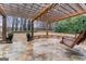 Backyard stone patio featuring string lights and a wooden swing, perfect for outdoor relaxation at 1110 Eagles Brooke Dr, Locust Grove, GA 30248