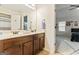 Bathroom featuring double sink vanity with brown cabinets, light countertops, and an adjacent bedroom view at 1110 Eagles Brooke Dr, Locust Grove, GA 30248