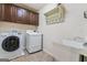 Functional laundry room with washer, dryer, dark cabinets, and a utility sink at 1110 Eagles Brooke Dr, Locust Grove, GA 30248