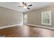 Spacious bedroom with hardwood floors, white trim, ceiling fan, and natural light from the two windows at 309 Marbella Way, Mcdonough, GA 30252