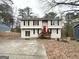 Two-story home featuring a wooden porch, spacious driveway, and colorful red front door at 5743 Rock Rd, Union City, GA 30291