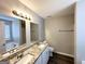 Bathroom featuring a double sink granite vanity with white cabinets, modern fixtures, and recessed lighting at 1202 Grove Trail Pass, Douglasville, GA 30134