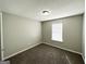 Bedroom featuring neutral walls, plush carpeting, and a window offering natural light at 1202 Grove Trail Pass, Douglasville, GA 30134