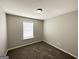 Bedroom featuring neutral walls, plush carpeting, and a window offering natural light at 1202 Grove Trail Pass, Douglasville, GA 30134