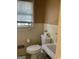 Bright bathroom with a window, tiled walls, and a classic white toilet and sink at 1125 Carlo Sw Ct, South Fulton, GA 30331