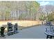 Expansive backyard with a large patio, a decorative water feature, and bordered by tall mature trees at 115 Foxford Run, Tyrone, GA 30290