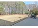 Large backyard with an expansive lawn featuring a patio area with an outdoor dining set and mature trees at 115 Foxford Run, Tyrone, GA 30290