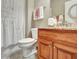 This half bathroom has a granite vanity, updated fixtures, and a shower curtain at 115 Foxford Run, Tyrone, GA 30290