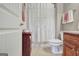This half bathroom has a farmhouse shower curtain, wood vanity, and a toilet at 115 Foxford Run, Tyrone, GA 30290
