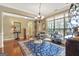 Elegant dining area showcases a beautiful rug, chandelier, and large windows for natural light at 115 Foxford Run, Tyrone, GA 30290