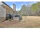 Side view of a home exterior with an outdoor grill and patio area at 115 Foxford Run, Tyrone, GA 30290