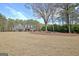 A long driveway leads to a beautifully designed house, complemented by a sprawling lawn and mature trees at 115 Foxford Run, Tyrone, GA 30290