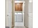 Bright laundry room with white appliances, storage cabinetry, and tiled floor at 115 Foxford Run, Tyrone, GA 30290