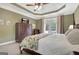 Beautiful bedroom with tray ceilings, french doors to the patio, and a large dresser at 115 Foxford Run, Tyrone, GA 30290