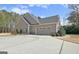 Side view of a house with an attached two-car garage and an ample driveway at 115 Foxford Run, Tyrone, GA 30290