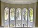 Interior shot of arched windows framing a picturesque view of mature trees and tranquil lake at 125 Turnberry Cir, Fayetteville, GA 30215