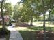 Sidewalk leading toward the lake; mature trees and lush lawn; house visible in background at 125 Turnberry Cir, Fayetteville, GA 30215