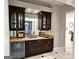 Sophisticated bar area with wine cooler, granite countertop, custom cabinets, and mirrored backsplash detail at 125 Turnberry Cir, Fayetteville, GA 30215