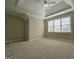 Large bedroom features tray ceiling, plush carpet, and natural light from a window at 125 Turnberry Cir, Fayetteville, GA 30215