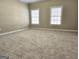 Spacious bedroom with neutral carpet, two windows with blinds, and electrical outlets along the walls at 125 Turnberry Cir, Fayetteville, GA 30215