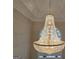 A stunning chandelier with intricate crystal detailing hangs from the ceiling of a well lit room at 125 Turnberry Cir, Fayetteville, GA 30215