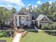 Brick home with manicured lawn and mature trees showcases its symmetrical design and stately white columns at 125 Turnberry Cir, Fayetteville, GA 30215