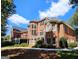 Brick home featuring balconies, arched windows, and lush landscaping, highlighting its elegant architectural design at 125 Turnberry Cir, Fayetteville, GA 30215
