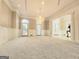 Spacious living room featuring a chandelier, plush carpeting, and double doors leading to an outdoor area at 125 Turnberry Cir, Fayetteville, GA 30215