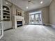 Spacious living room with fireplace, built-in shelving, and french doors with lake views at 125 Turnberry Cir, Fayetteville, GA 30215