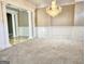 Bright living room showcasing plush carpeting, decorative columns and a chandelier with decorative wainscoting at 125 Turnberry Cir, Fayetteville, GA 30215