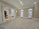 Large living room featuring plush carpeting, decorative columns, wainscoting, and double doors at 125 Turnberry Cir, Fayetteville, GA 30215
