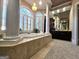 Elegant main bathroom featuring a large soaking tub, chandelier, and dual sinks with vanity at 125 Turnberry Cir, Fayetteville, GA 30215