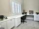 A dedicated office space featuring built-in cabinets, a wide workspace, and shuttered windows at 125 Turnberry Cir, Fayetteville, GA 30215