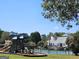 Exterior shot of a community playground, and tennis court, surrounded by trees, with a clear sky above at 125 Turnberry Cir, Fayetteville, GA 30215