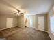 Spacious carpeted bedroom featuring neutral walls, ceiling fan, and ensuite bathroom with a window at 4734 Campbellton Sw Rd, Atlanta, GA 30331